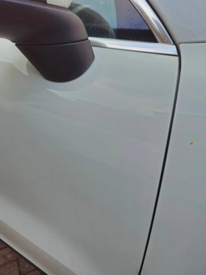 White Porsche Cayenne door after Derrick's paintless dent repair